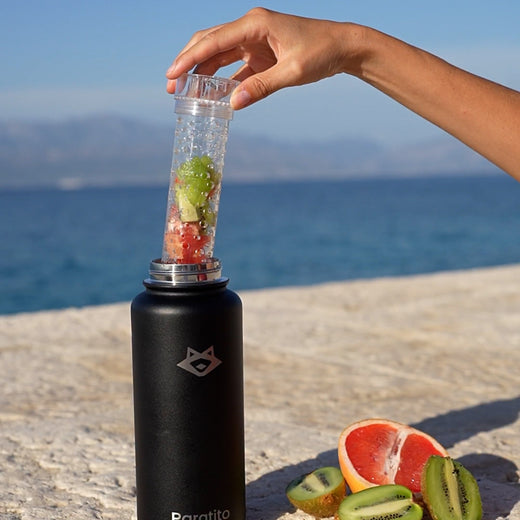 Der Fruchteinsatz wird in eine schwarze PARATITO Edelstahl-Trinkflasche eingesetzt